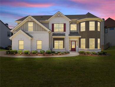 View of front of house featuring brick siding, board and batten siding, a front lawn, and roof with shingles