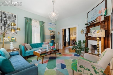 Large Living room featuring 10' ceilings with beautifully refinished original fireplace and mantel with tile facade and tile flooring.