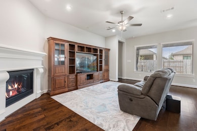 Gather and relax in the inviting family room, complete with a warm gas fireplace, elegant wood flooring, and abundant natural light!