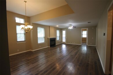 Unfurnished living room with dark wood-style floo
