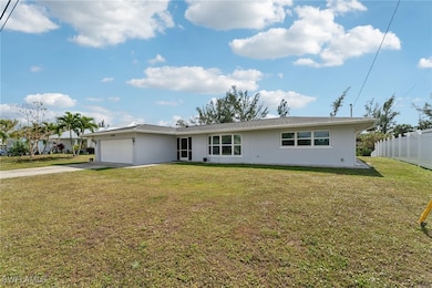 Single story home with a garage and a front lawn