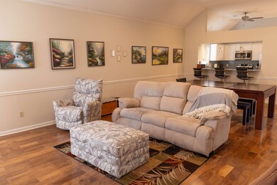 Living area with wood finished floors, crown moldi