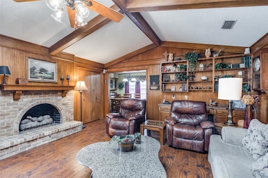 Living room featuring wooden walls, a gas fireplac