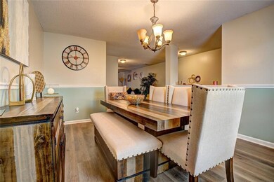 Dining space with wood finished floors and a chandelier