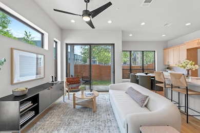 Living area with visible vents, light wood-style 