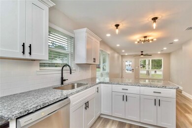 Images are of a model home and may include custom design features not available in other homes. Kitchen featuring white cabinets, plenty of natural light, light stone countertops, and recessed lighting