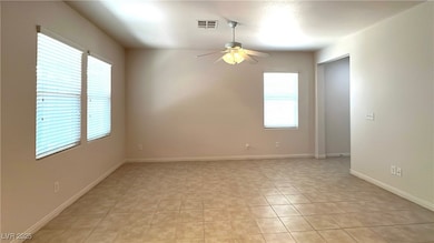 Spare room with a ceiling fan and light tile patte
