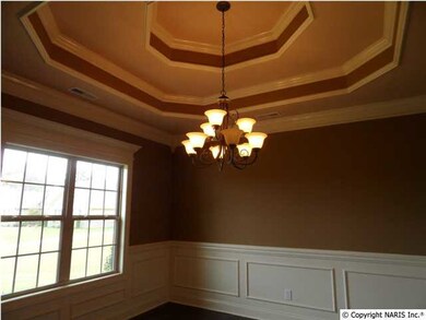 Dining room with double trey ceiling, hardwood floors, shadow box and chair rail.