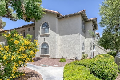 View of front of house with stucco siding and a ti