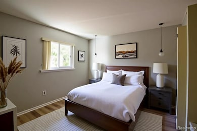 Bedroom with wood finished floors and baseboards