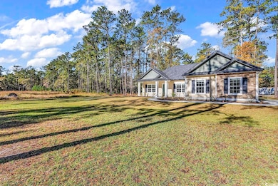 View of front of home with a porch, a front yard, and stone siding