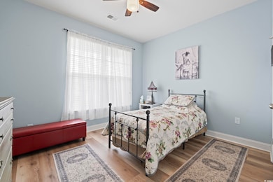Bedroom with wood finished floors, baseboards, and ceiling fan