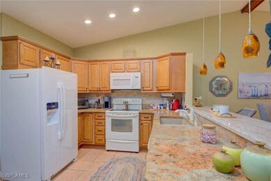 Kitchen featuring white appliances, a sink, light