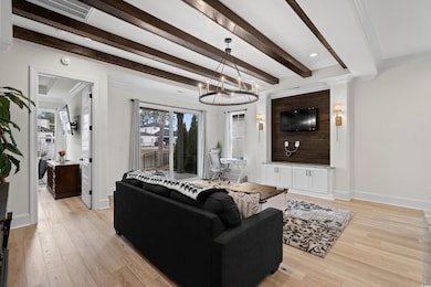 Living room featuring beam ceiling, crown molding,