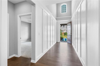 Hallway featuring dark wood-style floors and baseboards