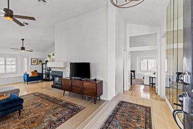Living area with a ceiling fan, high vaulted ceili