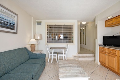 Living room with a textured ceiling and light tile patterned floors