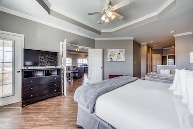 Bedroom with ceiling fan, ornamental molding, hard