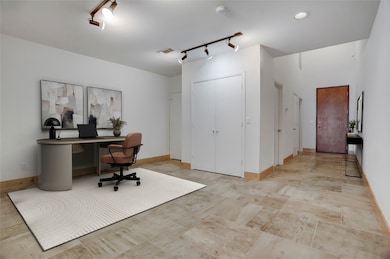 The open-concept guest room offers flexible use. Ideal for a home office, den, or creative space. Double doors conceal the closet, with the guest bath just behind and the utility room positioned at the end of the hall. This photo is virtually staged.