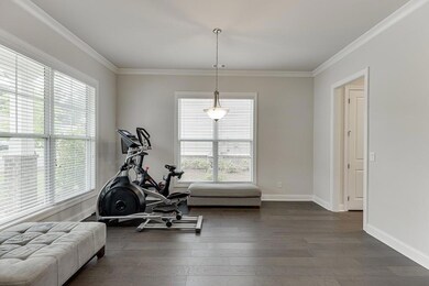 Dining room featuring plenty of light, dark wood-type flooring and crown molding