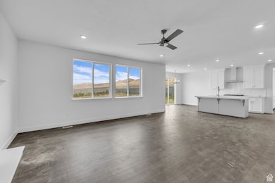Family room with large windows and ceiling fan.