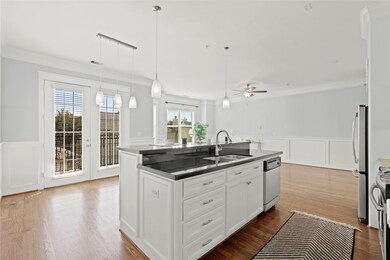 Crisp white cabinetry, central island with a sink,