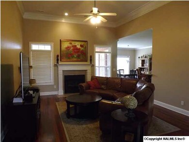 Welcoming Great Room has gorgeous hardwood floors, 12' Ceiling, Deep Crown Moulding & Fireplace