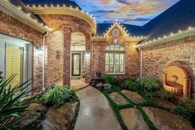 Enter the courtyard to the grand rotunda like entrance to the glass front door. Stone pavers, water feature and more well thought out landscaping create a welcoming feeling as you walk towards the entry. The double doors on the left of the picture gives access to one of the secondary bedrooms.