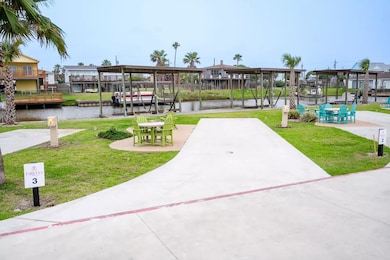 View of property's community featuring a water view, a lawn, a boat dock, and boat lift