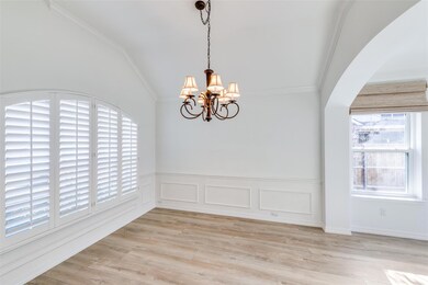 Dining room featuring vaulted ceiling, an inviting chandelier, a wealth of natural light, and ornamental molding