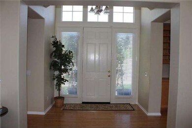 Bright entry with vaulted ceiling and wood floors.