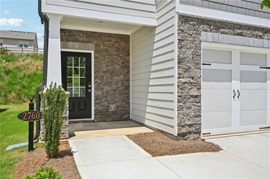 Property entrance with stone siding and a garage