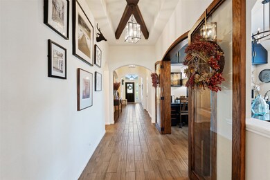 As you proceed down the main hallway toward the formal dining area, complete with stained, glass inset doors, notice the ceiling details. Gorgeous crisscross box beams in the tray ceiling and lantern style lighting add a custom feel.