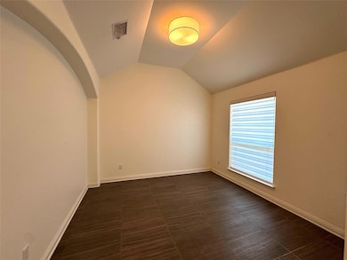 Empty room with baseboards and vaulted ceiling