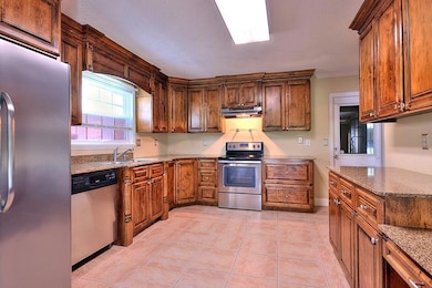 Kitchen with Granite Counter Tops and Stainless Steel Appliances.