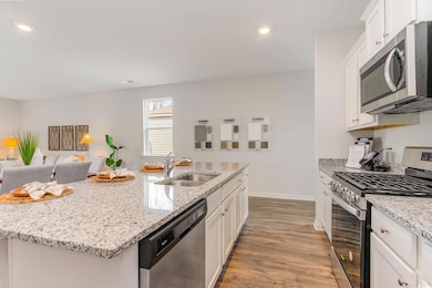Kitchen featuring wood finished floors, white cabi