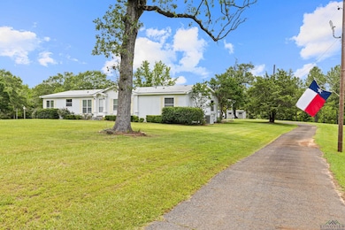 View of front of property with a front lawn and asphalt driveway