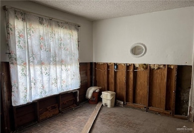 Spare room with brick floor and a textured ceiling