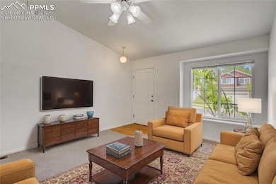 Virtually Staged Living room with vaulted ceiling, a ceiling fan, baseboards, and light carpet