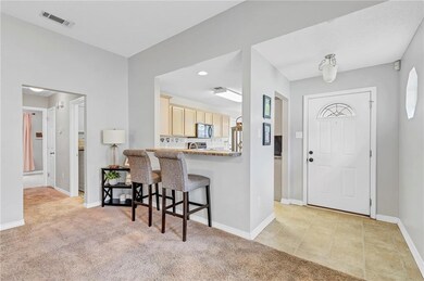 Foyer entrance with visible vents, baseboards, and