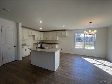 Kitchen with a chandelier, dark wood-style floorin