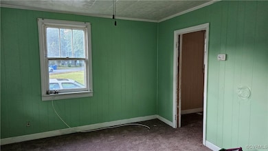 Spare room with baseboards, ornamental molding, an