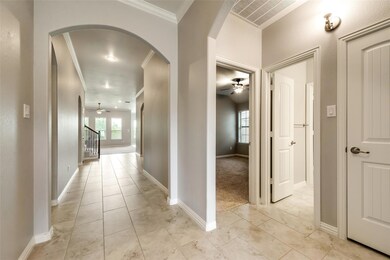 Hallway featuring crown molding and light colored carpet