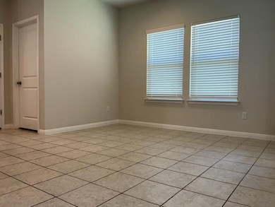 Empty room with light tile patterned floors and b