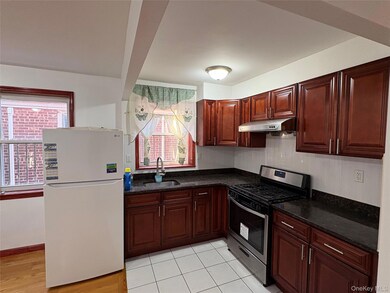 Kitchen featuring stainless steel range with gas cooktop, freestanding refrigerator, plenty of natural light, and dark stone counters