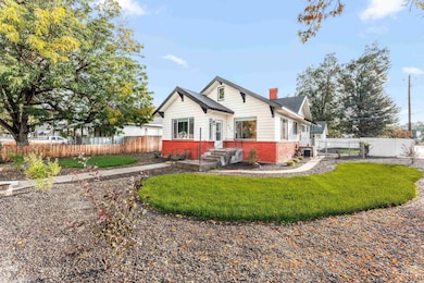 Rear view of house featuring a chimney and brick siding