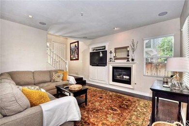 Dark hardwood floors and cozy fireplace enhance fa