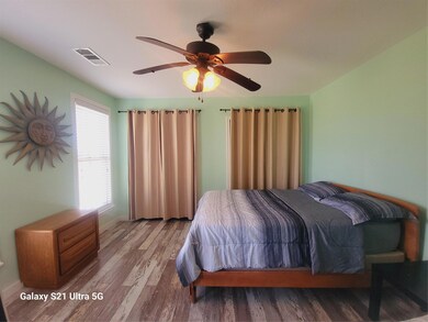 Bedroom with wood finished floors and a ceiling f