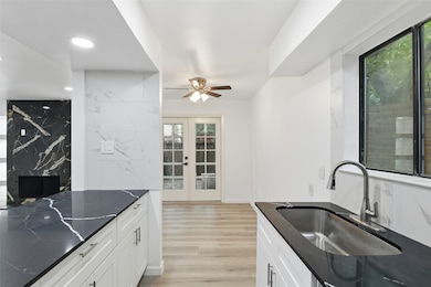Kitchen featuring light wood-style flooring, recessed lighting, white cabinets, dark stone counters, and ceiling fan