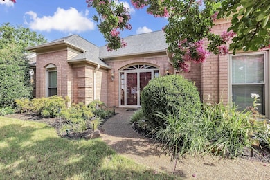 View of front of home with brick siding, a shingled roof, and a front yard
